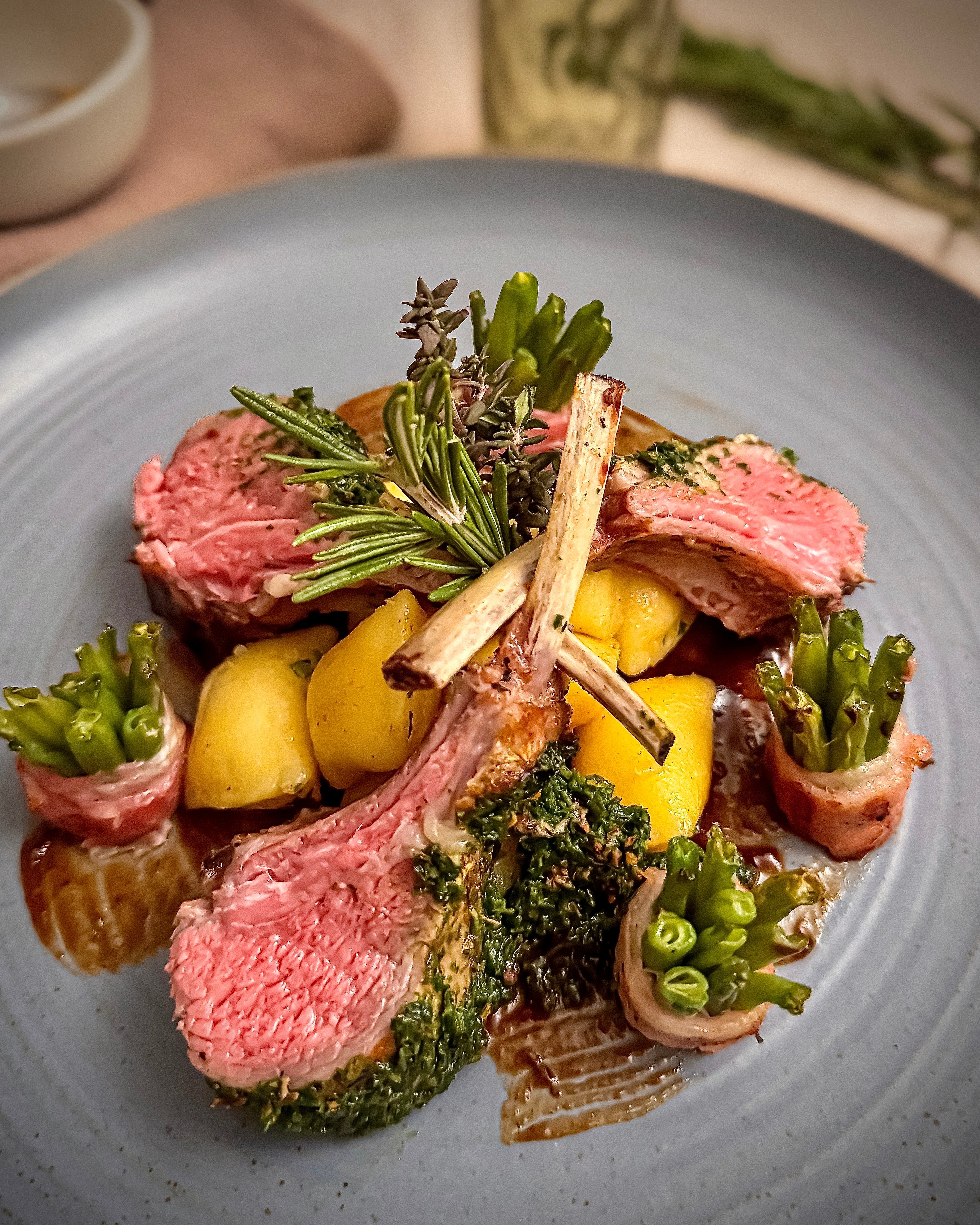 Weidelamm French-Racks mit Kräuterpesto und Bohnenbündel an Rosmarinkartoffeln