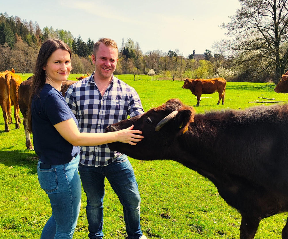 Kathi und Timo mit einer Kuh auf der Weide