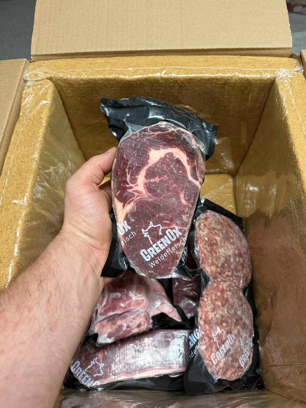Geöffnete Versandbox mit vakuumiertem GreenOx-Ribeye